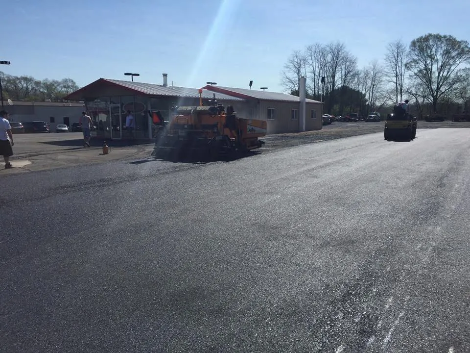 Crew resurfacing a worn asphalt parking lot