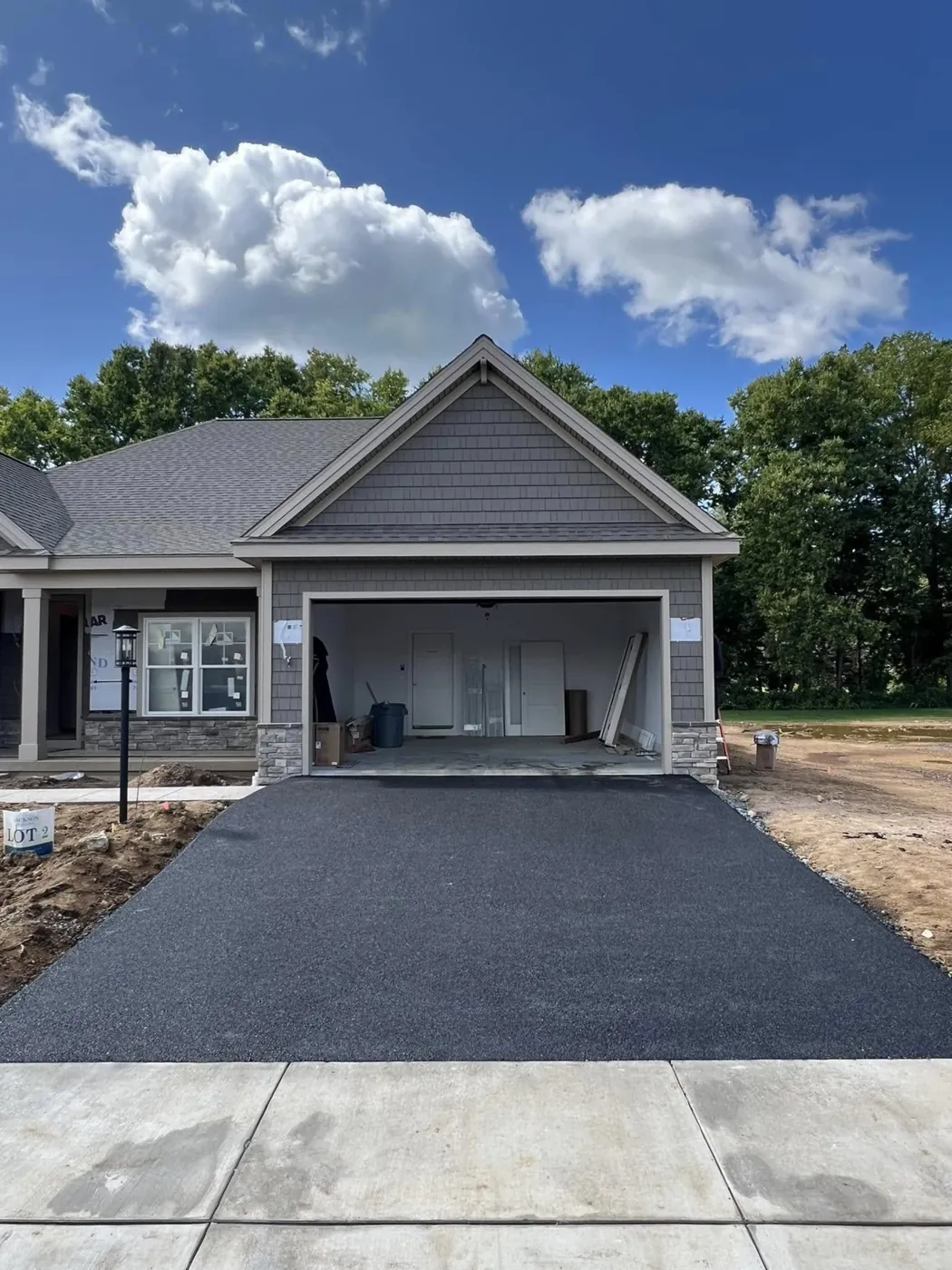 Fresh asphalt in front of a three car garage
