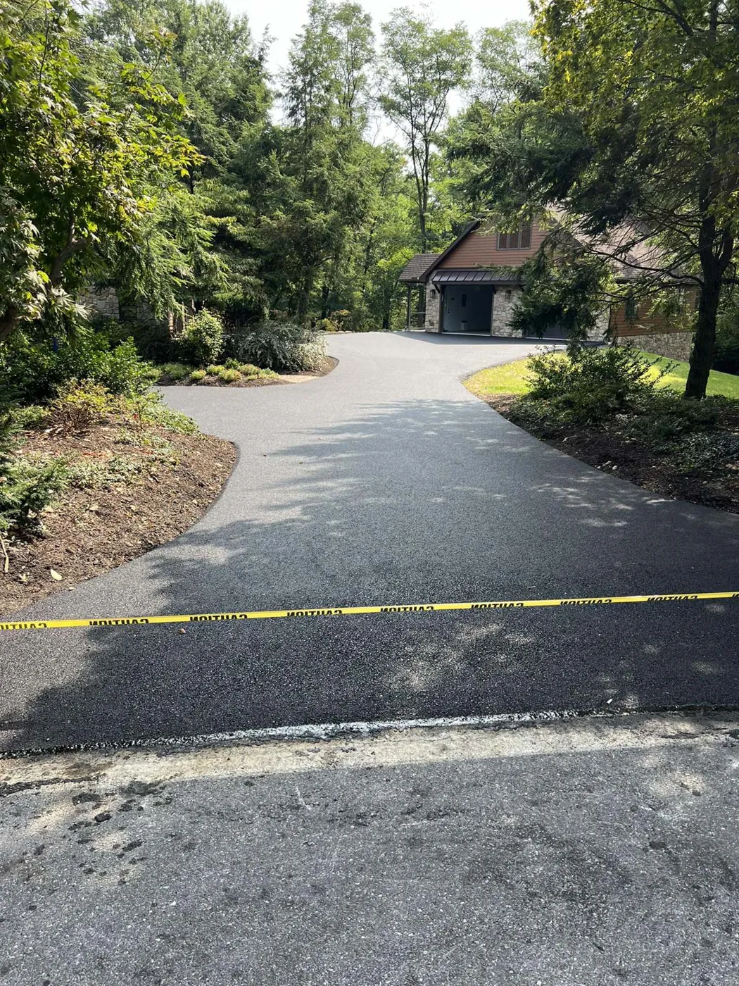 Tree lined asphalt driveway, resurfaced