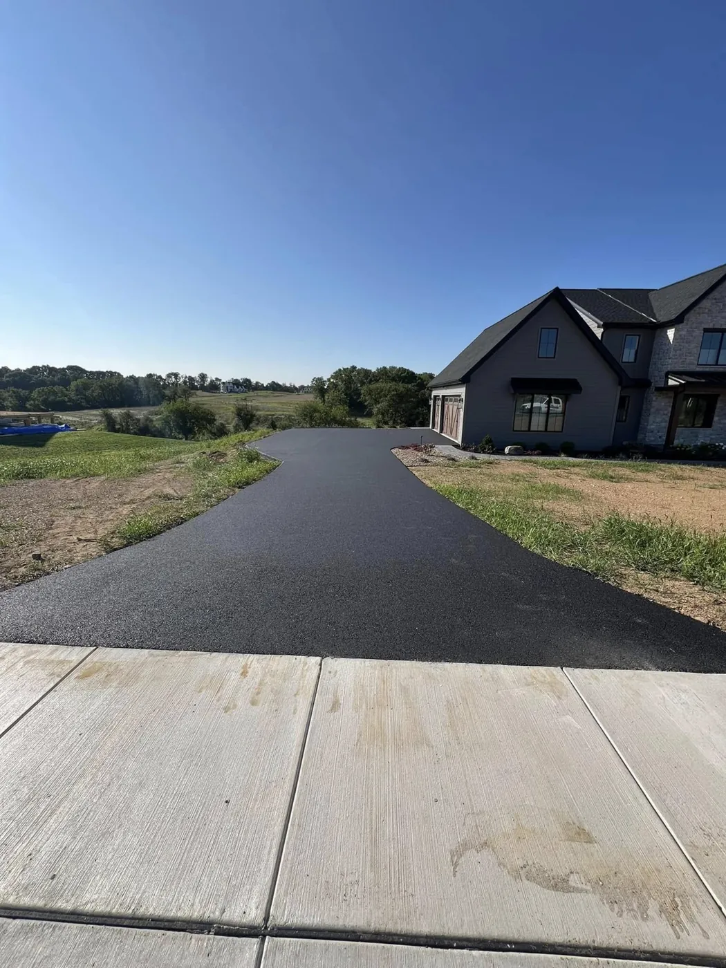 Wide asphalt apron and driveway, compacted and finished