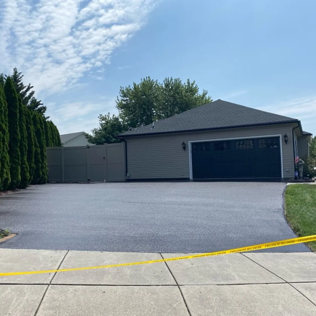 Sealed asphalt driveway leading to a garage